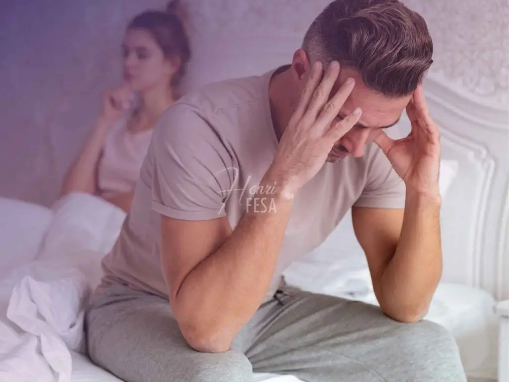 Mulher sentada na cabeceira da cama com expressão de reflexão profunda enquanto homem está sentado na lateral da cama com as mãos na cabeça, também com a expressão de reflexão profunda!