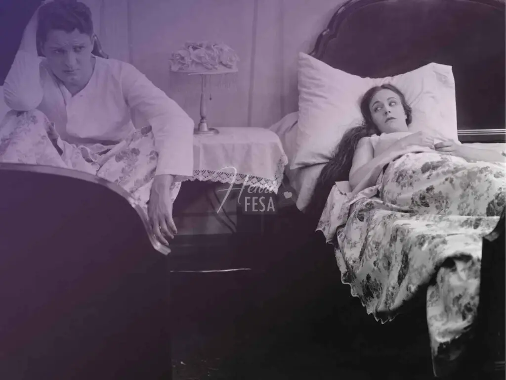 Mulher deitada em uma cama de casal pensativa e homem deitado em outra cama logo ao lado com ar de tristeza e preocupação, ambos separados por um móvel de cabeceira!