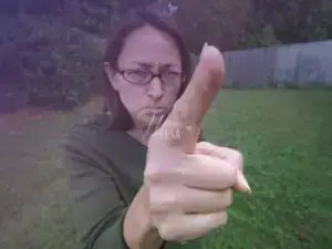 Mulher de óculos, casaco verde-escuro, apontando o dedo e expressando autoritarismo!