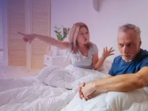 Mulher gritando com homem na cama e apontando o dedo para ele sair da cama!
