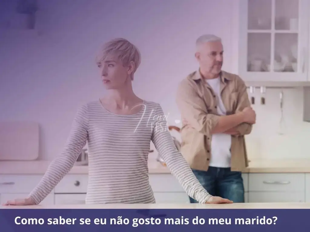 Mulher parada enfrente a ilha da cozinha, com as mãos sobre a pedra central, refletindo sobre seus sentimentos pelo marido, que está logo atrás de braços cruzados, encostado na bancada da parede, refletindo sobre tais questões!