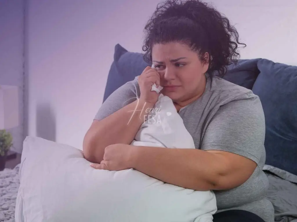 Mulher acima do peso, sentada no sofá chorando!