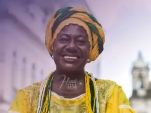 Imagem de uma mulher trajada como uma baiana típica das religiões e cultura afro-brasileira com um belíssimo sorriso no rosto!