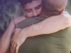 Dois homens abraçados e com os olhos fechados, um abraço caloroso e emocionado!