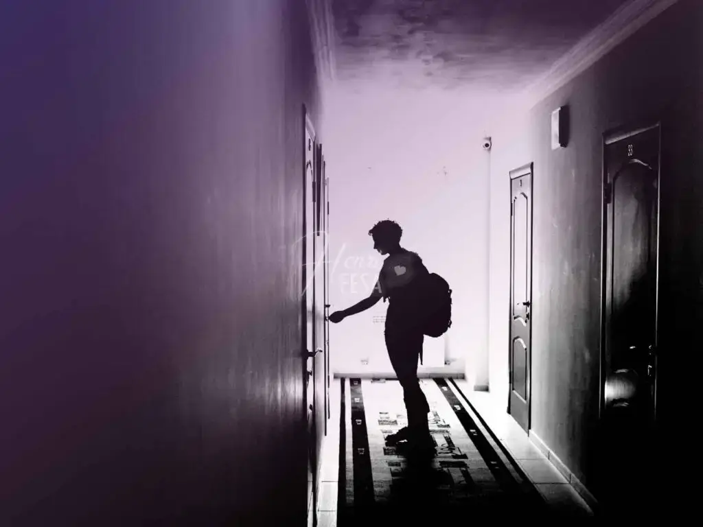 Mulher de mochila nas costas abrindo a porta pelo lado de fora após estar chegando do trabalho!