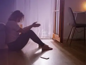 Mulher sentada ao chão, pensativa, cabisbaixa, pensando no relacionamento!