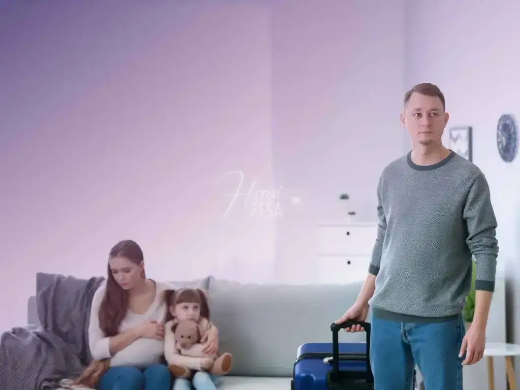 Homem saindo com mala, e esposa e filha pequena triste, observando, sentadas no sofá.