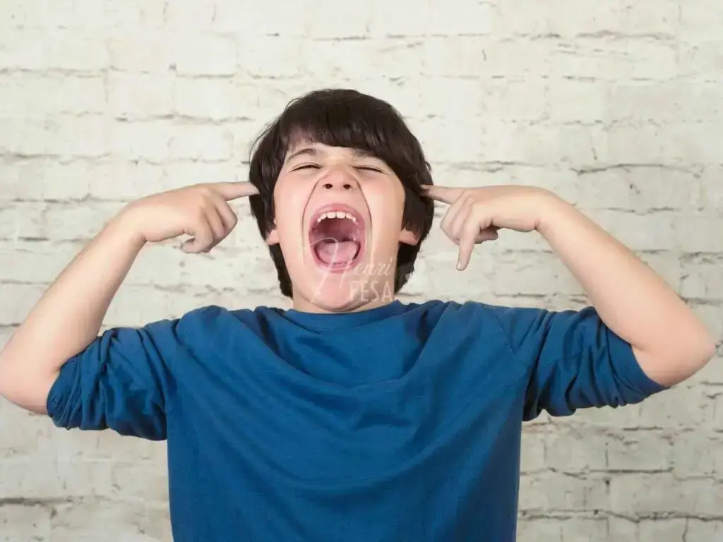 Menino birrento gritando e tampando os ouvidos!