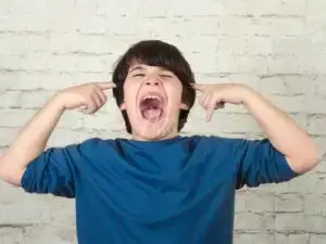 Menino birrento gritando e tampando os ouvidos!