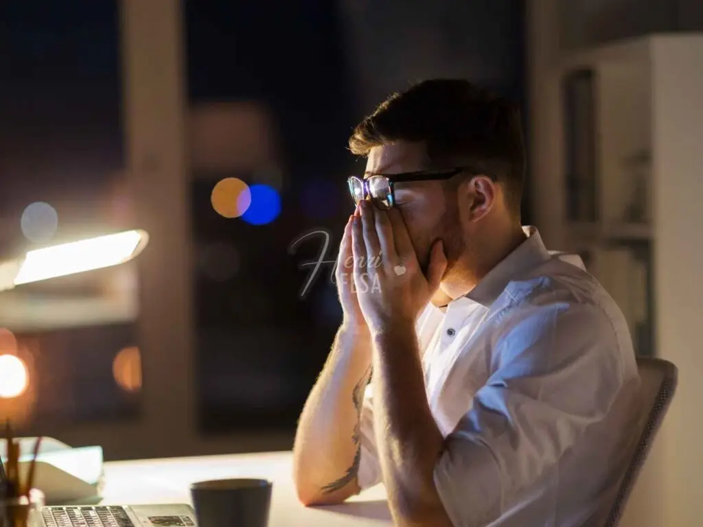 Homem exausta de trabalhar com as mãos no rosto em frente ao computador!