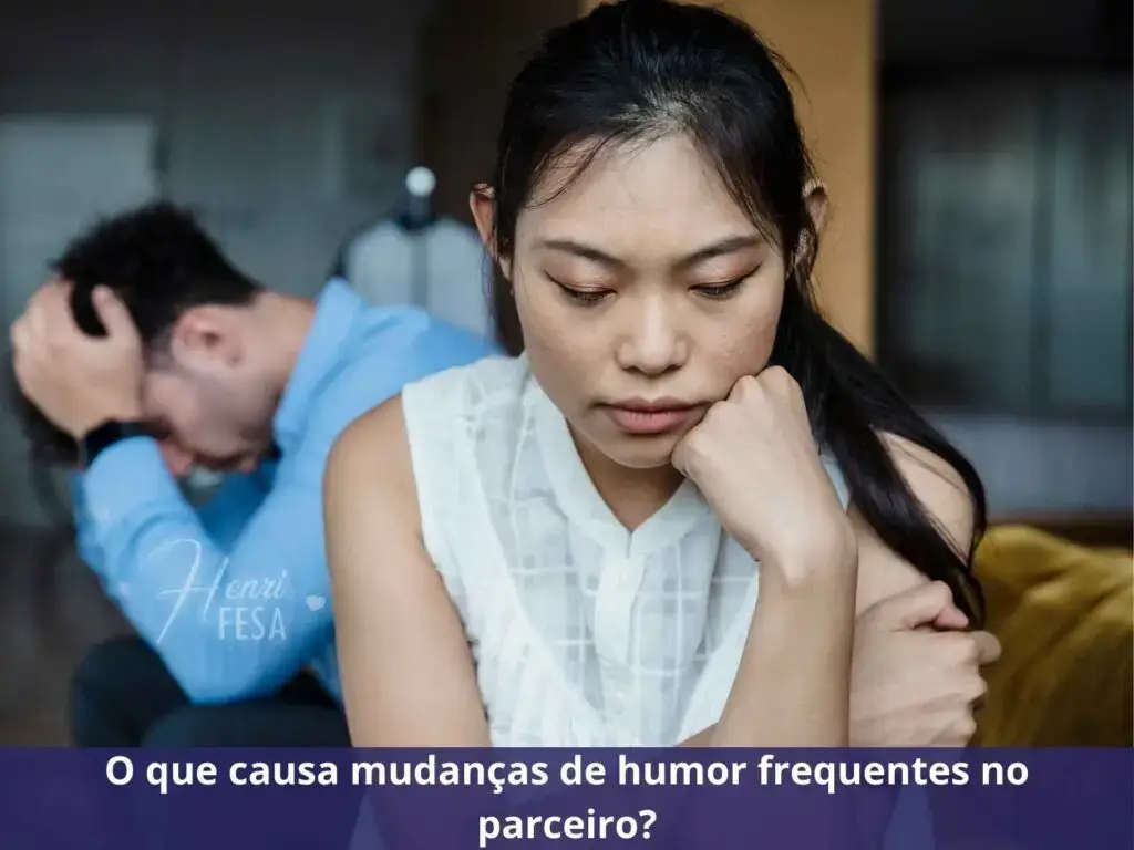 Esposa sentada ao sofá em posição de pensadora introspectiva, enquanto marido está senado logo ao fundo a imagem com as mãos na cabeça em expressão de insatisfação!