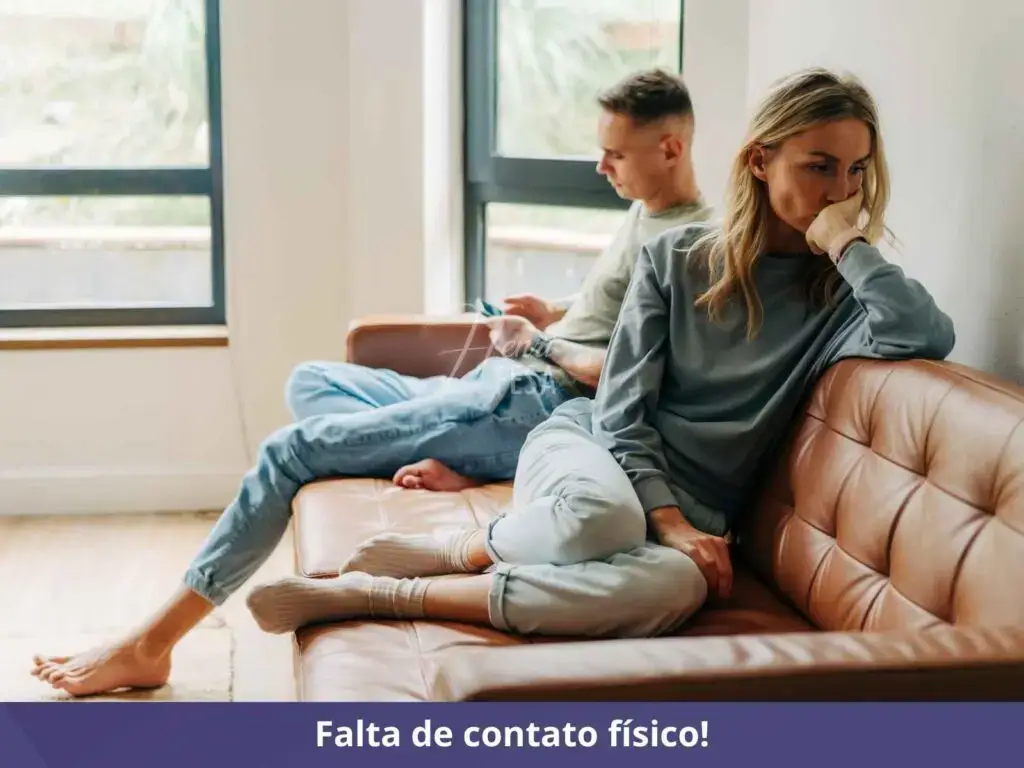 Homem sentado no sofá, mexendo no celular, mulher descontente e pensativa com a mão no rosto, sentada na outra ponta do sofá!