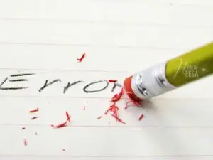 Imagem ilustrativa da palavra "erro" escrita a lápis em uma folha de carderno e sendo apagada com a borracha do lado oposto a ponta do lápiz, sinalizando que o medo de errar no casamento deve ser apado da vida do casal!