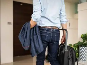 Homem saindo de casa com mala para viajar ao não dar satisfação no relacionamento!
