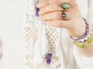 Médium segurando um guia, com anéis e pulseiras características de quem pratica o trabalho mediúnico!